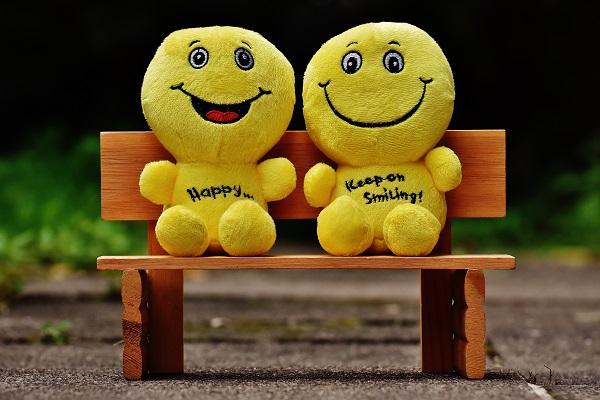 miniature yellow plush gingerbread men sitting on tiny park bench
